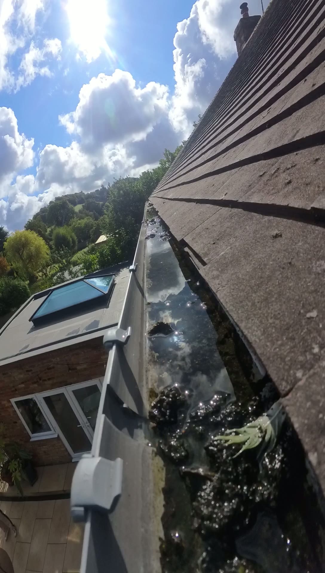 Insta360 pole-camera view inside the guttering at a five-bedroom home near High Wycombe, showing standing water and debris sitting in the gutter run
