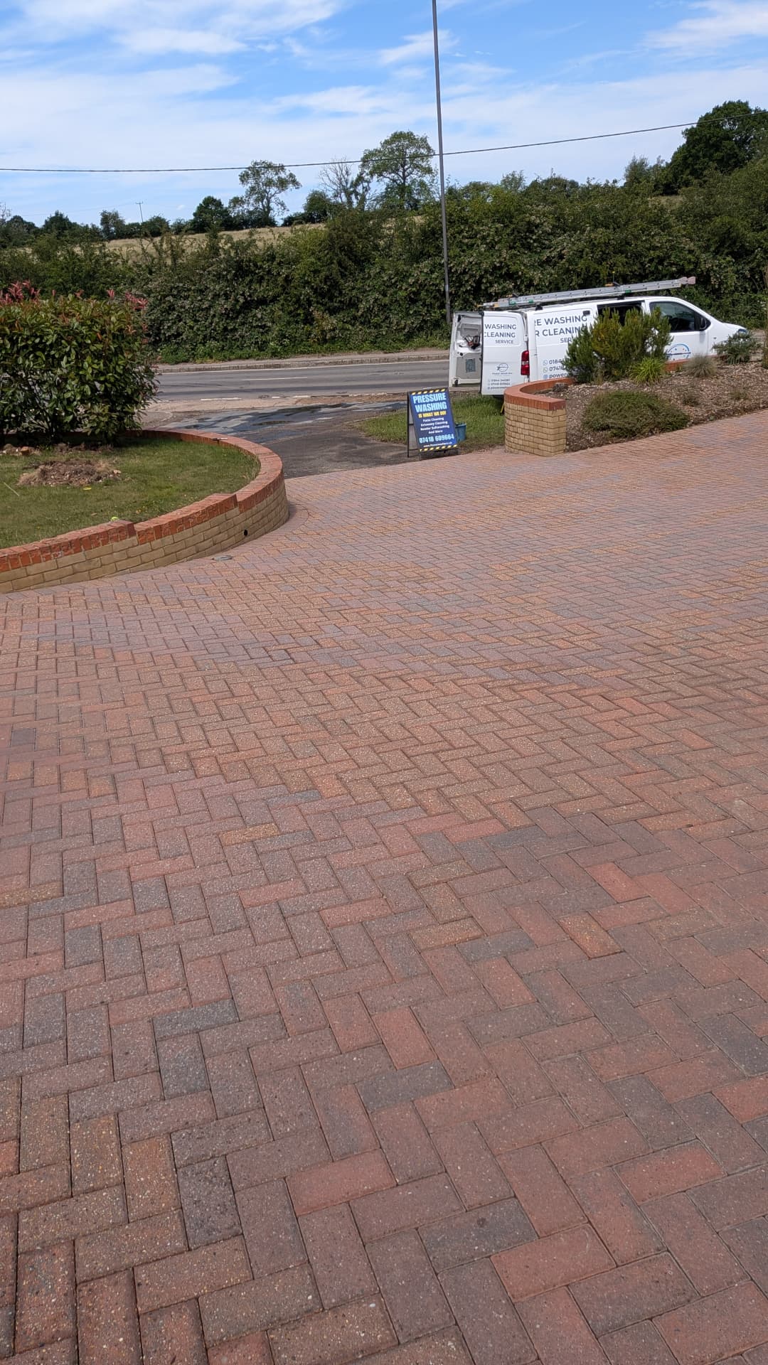 Sweeping block paving driveway freshly cleaned by Power Wash Pro with van on the roadside